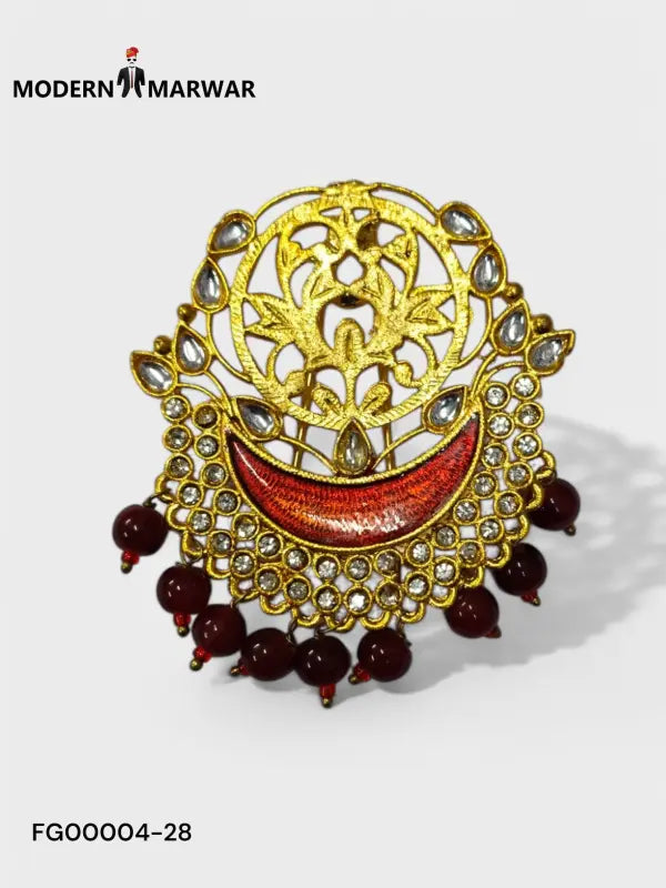 Intricate gold designer brooch for wedding attire adorned with red and sparkling gemstones
