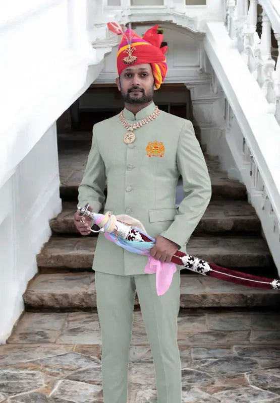 Elegant Jodhpuri suit in light green with embroidered logo Jodhpuri and a traditional sword accessory