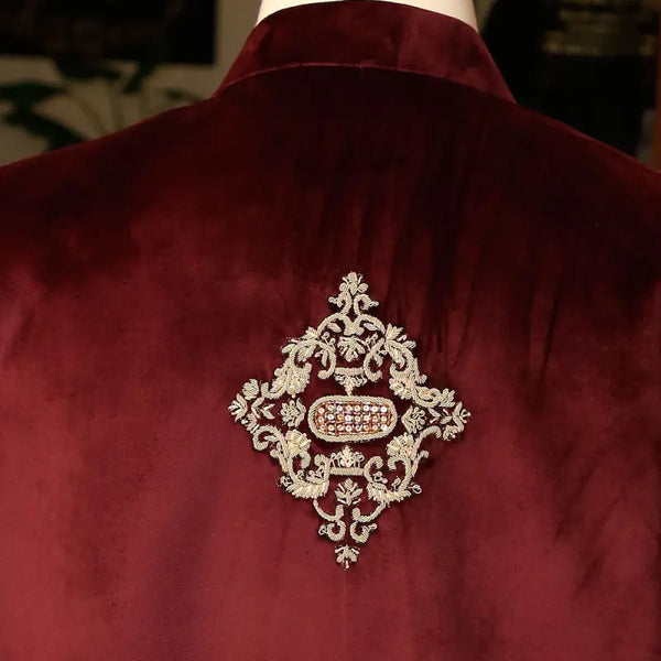 Exclusive men's designer coat in rich burgundy velvet with intricate embroidery detail on the back
