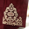 Close-up of exclusive men's designer coat featuring intricate gold embroidery on burgundy fabric