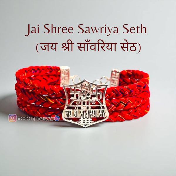 Jai Shree Sawriya Seth moli bracelet with red woven design and silver emblem for spiritual significance