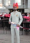 Elegant Jodhpuri suit for men in light green with traditional accessories and a colorful turban