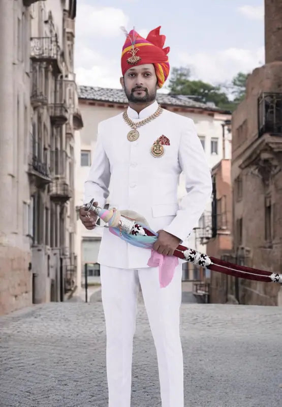 Elegant white Jodhpuri suit for men styled with traditional accessories and a turban