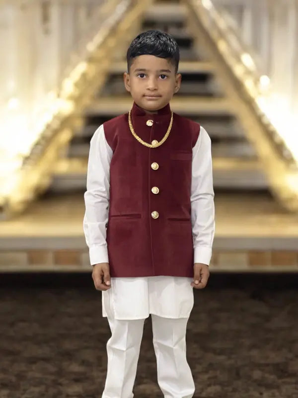 Elegant kids velvet koti in maroon with button details and layered over a white kurta for festive occasions