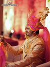 Elegant men's sherwani angarkha in gold with vibrant pink and orange turban, perfect for festive occasions