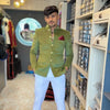 Stylish men's wedding coat suit in olive green with gold buttons and a coordinating pocket square
