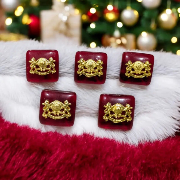 Set of five burgundy Chouhan logo buttons with gold detailing for decorative use