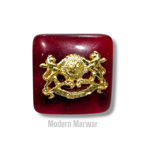 Chouhan logo button in deep red with a gold emblem design for stylish clothing accents