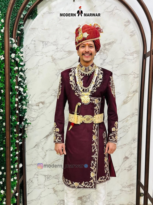 Designer maroon sherwani for men adorned with intricate golden embroidery and a decorative belt