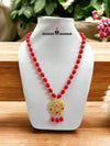 Red beaded necklace with a golden pendant featuring intricate design details