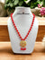 Red beaded necklace with a golden pendant featuring intricate design details