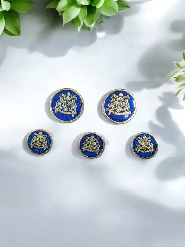 Set of royal metal buttons in blue featuring intricate gold designs, ideal for stylish garment accents