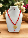 Elegant traditional necklace with pendant featuring vibrant red beads and a decorative design