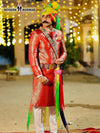 Stylish wedding groom sherwani in vibrant red with intricate patterns and colorful turban for traditional ceremonies