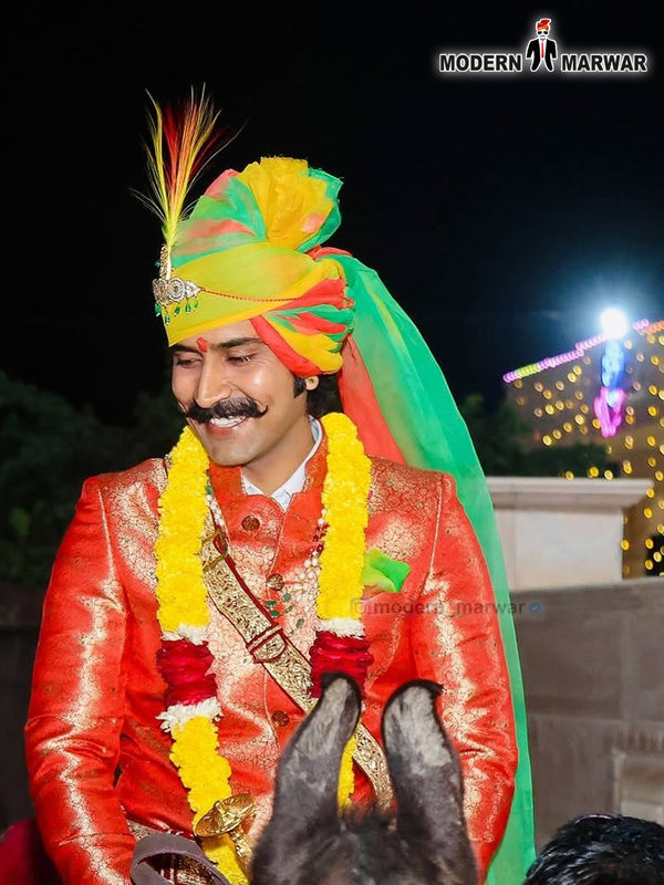 Traditional wedding groom sherwani in vibrant colors with regal accessories and a colorful turban