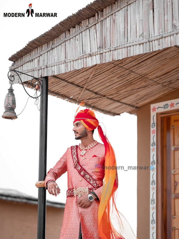 Elegant wedding groom sherwani in light pink with intricate designs, paired with a vibrant turban