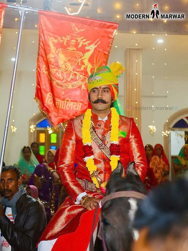 Traditional wedding groom sherwani in vibrant red with intricate designs and accessories for festive celebrations