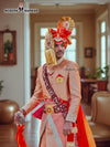 Elegant wedding groom sherwani in peach with intricate embroidery and vibrant orange accessories