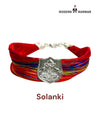 Default red woven fabric bracelet at an angle featuring the Solanki logo moli bracelet