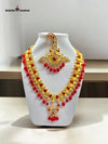Traditional Indian necklace set featuring intricate gold detailing and vibrant red beads