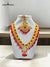 Traditional Indian necklace set featuring intricate gold detailing and vibrant red beads