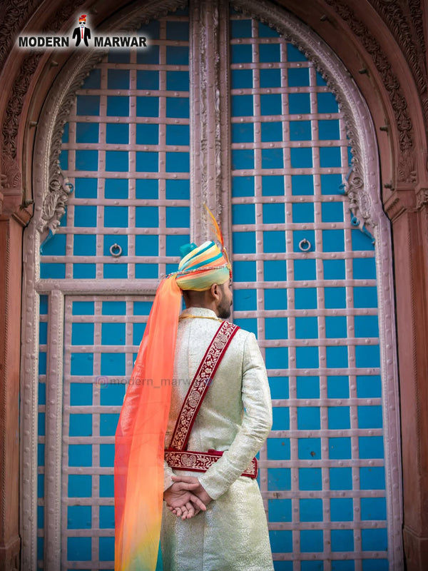 Elegant wedding groom sherwani in pastel green with intricate embroidery and colorful turban
