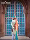 Elegant wedding groom sherwani with vibrant turban displayed against a historic backdrop