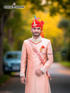 Elegant wedding groom sherwani in pastel pink with intricate embroidery and vibrant turban