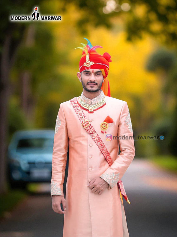 Elegant wedding groom sherwani in pastel pink with intricate embroidery and vibrant turban