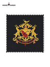 Detailed fabric swatch of Bhati Coat Suit for Men featuring a gold embroidered emblem on black background