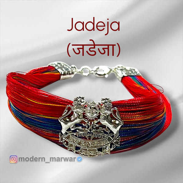 Jadeja logo moli bracelet with vibrant red and blue threads, featuring a decorative centerpiece