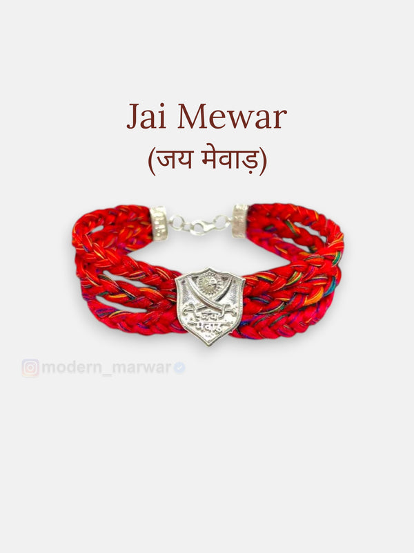 Default red fabric Jai Mewar moli bracelet with silver emblem, showcasing intricate braided design