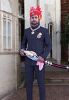 Elegant Jodhpuri suit for men in navy blue, styled with traditional accessories and a decorative turban