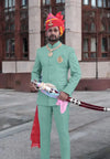Stylish Jodhpuri suit for men in light green with traditional accessories and a sword