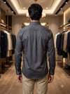 Men's gray plain shirt in smooth fabric, back view in a stylish boutique setting