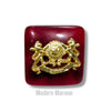 Chouhan logo button in deep red with a gold emblem design for stylish clothing accents