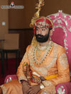 Stylish sherwani angarkha for men in orange with intricate embroidery and royal accessories