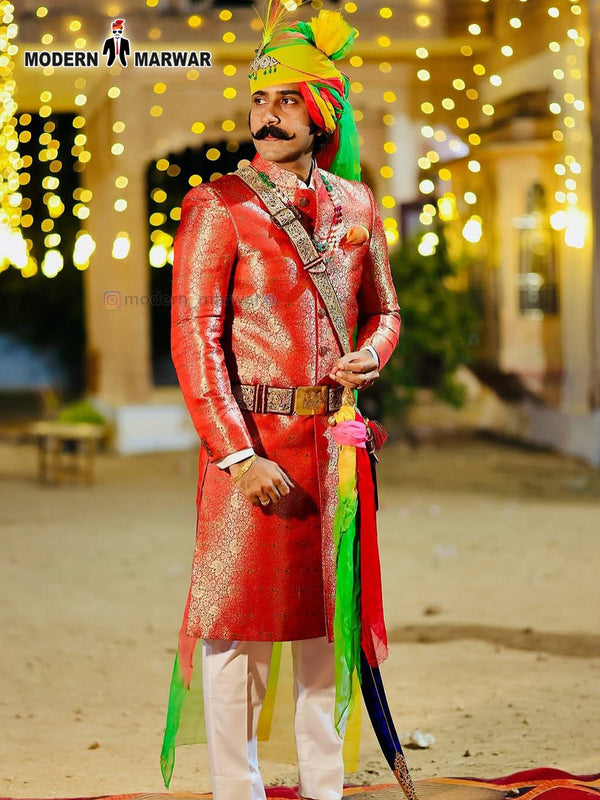 Stylish wedding groom sherwani in vibrant red with intricate patterns and colorful turban for traditional ceremonies