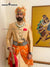 Elegant wedding groom sherwani in gold with intricate details and vibrant orange turban