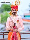Traditional wedding groom sherwani in peach with intricate embroidery and matching accessories