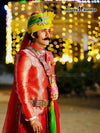 Elegant wedding groom sherwani in red adorned with intricate designs and a traditional turban