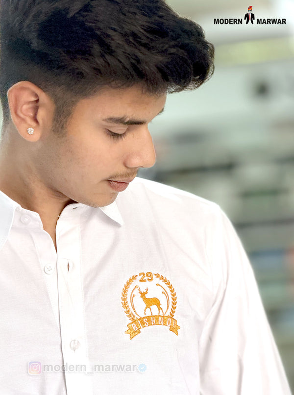 Young man wearing a white Bishnoi logo shirt white by SINGH with a detailed yellow emblem on the chest