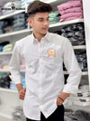 Young man wearing Bishnoi logo shirt white from SINGH standing in clothing store with folded shirts in the background