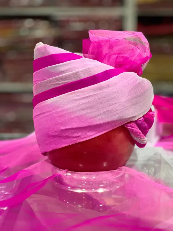 Bright pink Piyor Safa traditional headwear styled elegantly on a round object