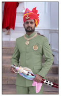 Elegant Rajputi Jodhpuri Suit in green worn by a man, paired with traditional accessories