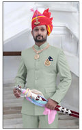 Elegant Rajputi Jodhpuri Suit in mint green for men, styled with royal accessories and a traditional turban.