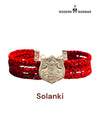Default red braided fabric bracelet shown from the front featuring the Solanki logo moli bracelet