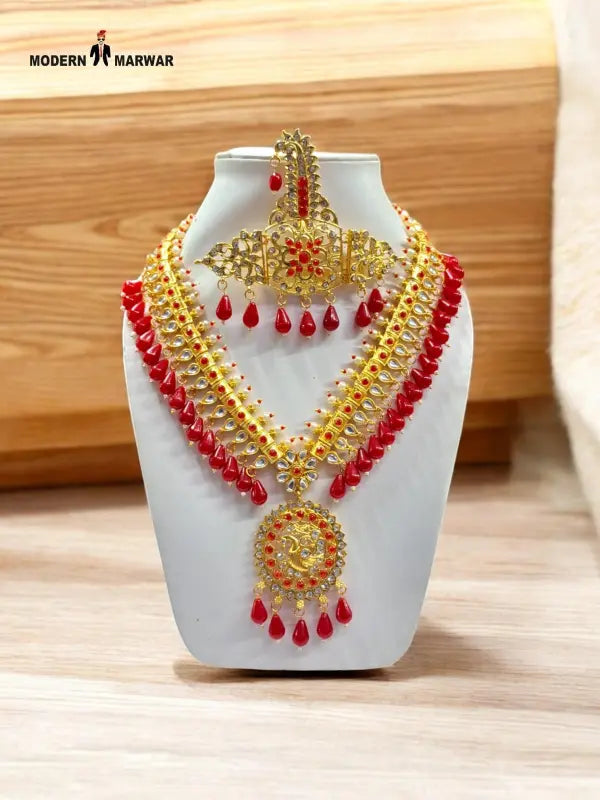 Traditional necklace set in gold with red embellishments, showcasing intricate design for festive occasions