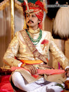 Elegant wedding groom sherwani in gold, adorned with intricate patterns and a matching turban