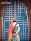 Elegant wedding groom sherwani in pastel green with intricate embroidery and colorful turban